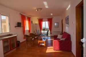 sala de estar con muebles de color rojo y mesa en Finca el Rabilargo, en Arroyomolinos de Montánchez