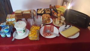 einen roten Tisch mit Speisen und Snacks in der Unterkunft Maison d'Hote le Relais de morville in Fresnes