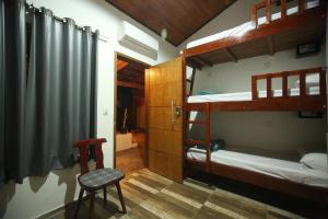 a room with two bunk beds and a chair at Savana Hostel in Sao Jorge