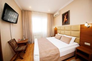 a hotel room with a bed and a flat screen tv at AMIGO Tuapse in Tuapse