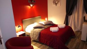 a bedroom with a bed with a red wall at Hôtel Montespan in Lussac-les-Châteaux