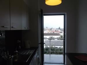 una cocina con una puerta que da a una ciudad en Penthouse City Center apartment, en Ponta Delgada