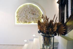 a vase with flowers on a table in a room at Central Apartments in Psiri in Athens