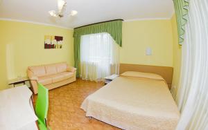 a room with a bed, chair and a lamp at Prichal Hotel in Kaluga