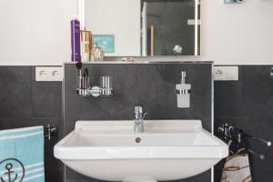 a bathroom with a white sink and a mirror at Ferienhaus Ostseehaus Seegras mit Kamin in Prerow +22 photos