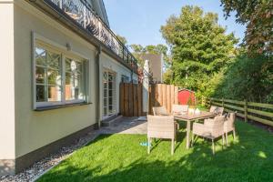 a patio with a table and chairs on the grass at Ferienhaus Ostseehaus Seegras mit Kamin in Prerow