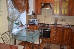 a kitchen with a glass table and a microwave at Lupova Home in Berdychiv