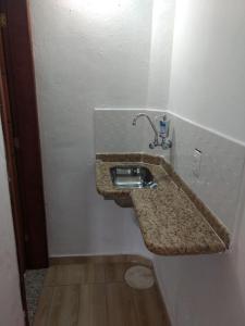 uma casa de banho com um lavatório na parede em Suites PRISCO BEACH em Cabo Frio