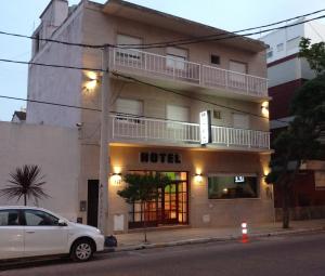 马德普拉塔Hotel Kube的停在酒店前的白色汽车