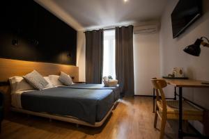 um quarto com uma cama, uma secretária e uma janela em CC Malasaña em Madri