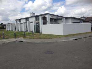 een wit gebouw met een witte muur en een straat bij Accommodation in Frimley in Hastings