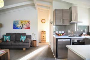 a kitchen and a living room with a couch at Auckland Clifftop in Auckland