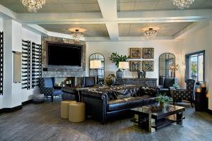 a living room with a leather couch and a tv at Oxford Suites Sonoma - Rohnert Park in Rohnert Park