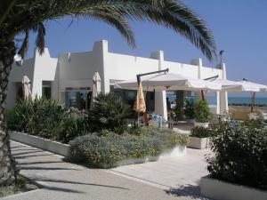 a white building with palm trees and umbrellas at Residence I Delfini in Cupra Marittima