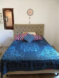 1 cama con edredón azul y almohadas en Jardin de Estrellas en San Marcos Sierras