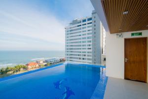 a large swimming pool with a view of the ocean at Soho Boutique Hotel in Danang