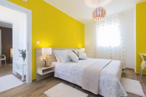 ein gelbes Schlafzimmer mit einem Bett und einer gelben Wand in der Unterkunft Dalmatian stone Villa Burica in Vinišće