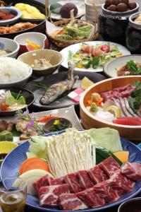 una mesa llena de diferentes tipos de alimentos en Syukubo Aso en Aso
