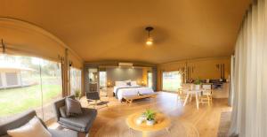
a living room filled with furniture and a large window at Olio Bello Lakeside Glamping in Cowaramup
