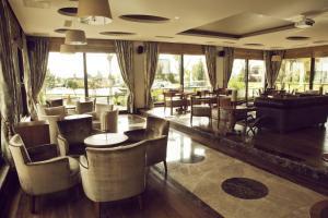 a restaurant with tables and chairs and windows at Hotel Suadiye in Istanbul