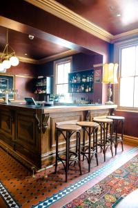 un bar con cuatro taburetes en una habitación en Shakespeare Hotel, en Sídney