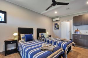 a bedroom with two beds with blue and white stripes at Dundee Beach Holiday Park in Dundee Beach