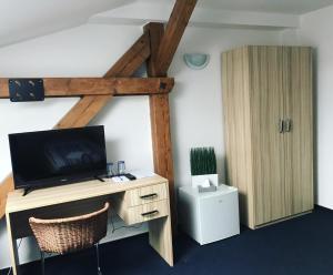 an office with a desk with a television and a cabinet at Penzion DMZ in Ostrava