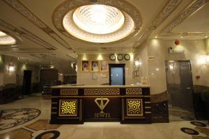 a large lobby with a large chandelier and a table at Al Adl Jewel Hotel in Makkah
