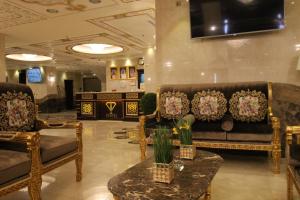 a lobby with couches and a table with flowers on it at Al Adl Jewel Hotel in Makkah