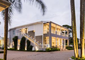 a large white building with palm trees in front of it at Avondale Boutique Hotel in Durban