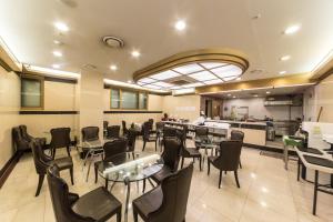 a restaurant with tables and chairs and a counter at Youngbin Hotel in Seoul