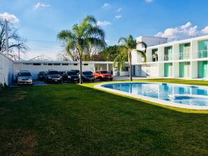 un parking avec des voitures garées devant un bâtiment dans l'établissement Hotel Palmas Cocoyoc, à Cocoyoc