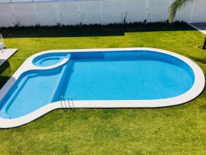 een groot zwembad in een tuin met gras bij Hotel Palmas Cocoyoc in Cocoyoc