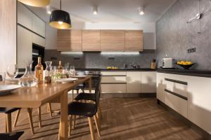 a kitchen with a wooden table with chairs and cabinets at Rezidence Adalbert in Valtice