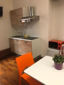 a kitchen with a white table and orange chairs at Casa Bella Pantheon in Rome