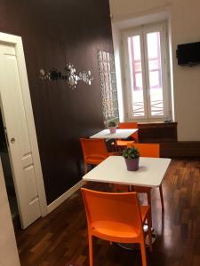 a dining room with orange chairs and a white table at Casa Bella Pantheon in Rome