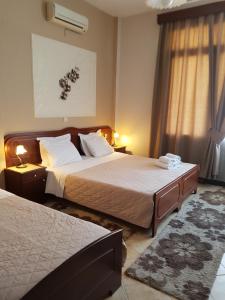 a hotel room with two beds and a window at Xenonas Arxontiko in Kato Loutraki
