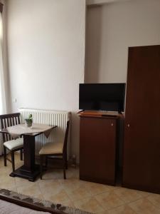 a dining room with a table and a tv on a cabinet at Xenonas Arxontiko in Kato Loutraki