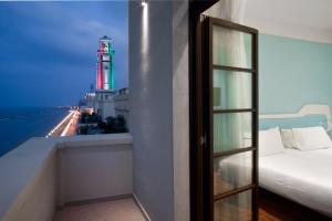 Zimmer mit einem Fenster und Blick auf einen Leuchtturm in der Unterkunft JR Hotels Bari Grande Albergo delle Nazioni in Bari