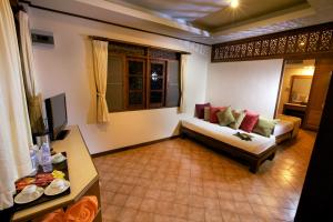 a living room with a couch and a tv at Smile House - Fisherman Village in Bophut