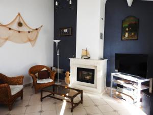 een woonkamer met een open haard en een televisie bij Superbe Maison de l'île de Ré in Le Bois-Plage-en-Ré