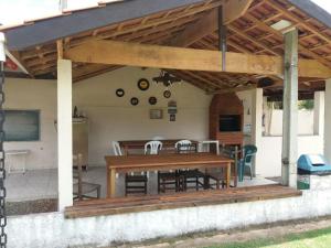 a wooden patio with a table and chairs at Pousada Encantos da Serra in Serra Negra