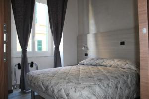 een slaapkamer met een bed in een kamer met een raam bij Ricci Rooms in Genua