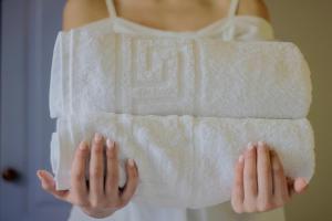 een vrouw in een witte badjas die een handdoek vasthoudt bij Kois Studios in Azolimnos