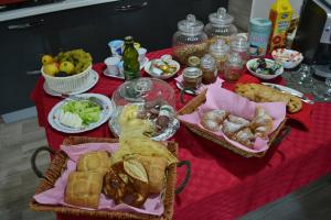 a table with baskets of food on a red table cloth at B&B La Casa Bianca di Porto Conte in Porto Conte