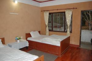 a bedroom with two beds and a window at Shrestha Hotel & Restaurant in Bandipur