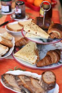 - une table avec des assiettes de différents types de pain et de viennoiseries dans l'établissement Les Renaudines, à Château-Renault