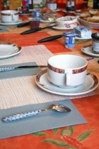 a table with a coffee cup and a spoon at Les Renaudines in Château-Renault