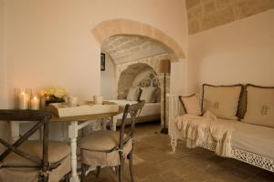 a room with a table and a bed and a couch at Hotel Don Ferrante in Monopoli