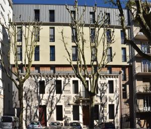 un immeuble d'appartements avec des arbres devant lui dans l'établissement Appartement T4 Vue Unique, à Rodez